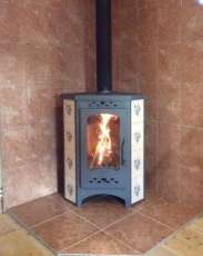Недорогая печь-камин Бавария угловая с плитой незабудка Амазонка бай фото в интерьере в Лиде